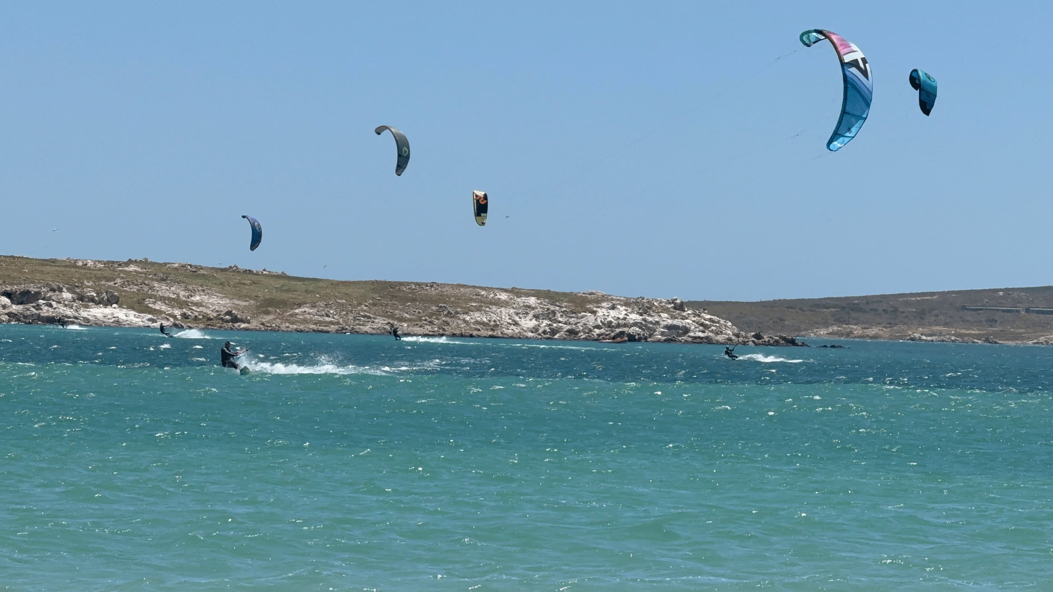 Kitesurfers carving through chop at Langebaan